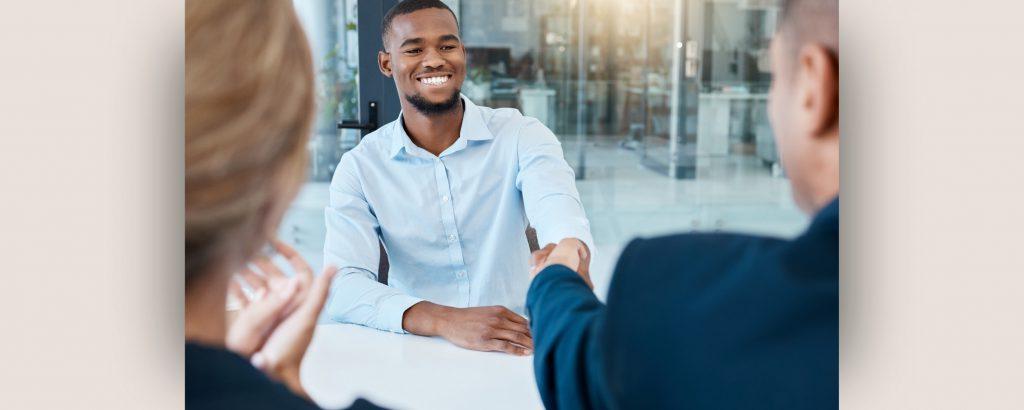 Image of new employee shaking hands with employer during onboarding process